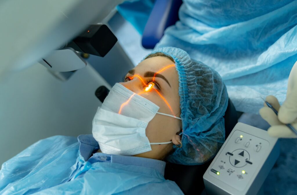 A patient undergoing laser eye surgery wearing a mask and surgical coat.