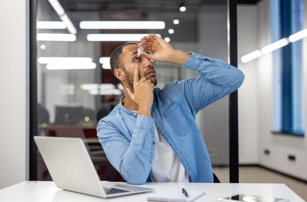 A person suffering with MGD using eye drops to relieve their symptoms