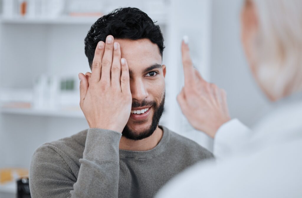 Man smiling during a basic vision test with eye doctor.