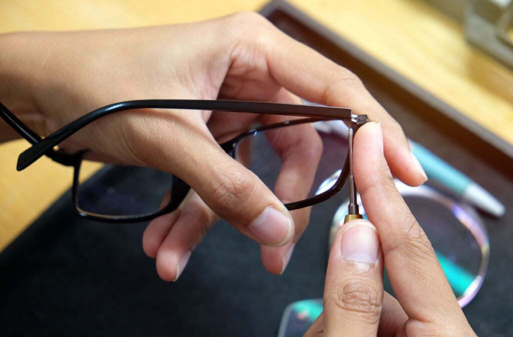 Close-up of an optician’s hands adjusting eyeglass frames for a proper fit.